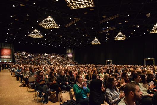 People sit and clap at Mitsubishi Electric Halle during the welcome of the first Semester at Hochschule Düsseldorf